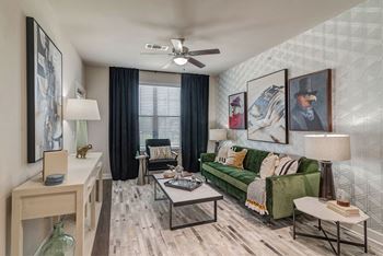 A living room with a green couch and a ceiling fan.